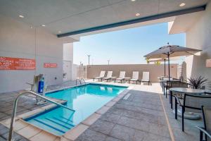 TownePlace Suites Fort Worth University Area/Medical Center في فورت وورث: مسبح على طاولات وكراسي في مبنى