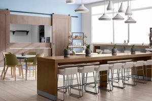 a kitchen with a bar with white stools at Element Baton Rouge South in Baton Rouge