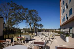 een patio met tafels en stoelen en een gebouw bij Element Baton Rouge South in Baton Rouge