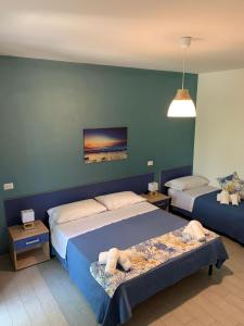 ein Schlafzimmer mit 2 Betten und einer blauen Wand in der Unterkunft B&B Giostemar - Playa Grande in Scicli