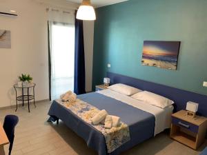 um quarto com uma cama grande e uma parede azul em B&B Giostemar - Playa Grande em Scicli