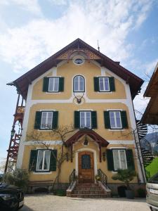 una grande casa gialla con persiane verdi di Villa Franz Xaver a St. Wolfgang