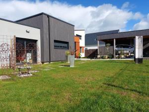a building with a grassy yard in front of it at Epiphytes et succulentes in Paimpol