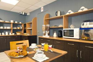 eine Küche mit einem Tisch mit Essen darauf in der Unterkunft Séjours & Affaires Nantes Ducs De Bretagne in Nantes + 17 Fotos