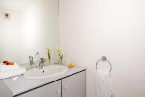 ein weißes Badezimmer mit Waschbecken und Spiegel in der Unterkunft Séjours & Affaires Nantes Ducs De Bretagne in Nantes