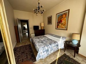 1 dormitorio con cama y lámpara de araña en Grande appartamento panoramico, en Lu
