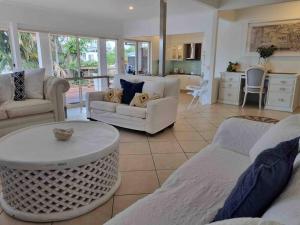 a living room with two couches and a table at Charming 4 Bedroom Waterfront Home W/ Pool Near Casino in Gold Coast