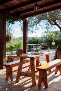 drewniany stół piknikowy i ławki na patio w obiekcie Tiria House Bosa - Casa Vacanze w mieście Bosa
