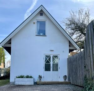 uma casa branca com uma janela e uma cerca em Lilla Villan em Höganäs