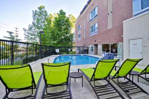 a group of green chairs and a swimming pool at SpringHill Suites Tallahassee Central in Tallahassee