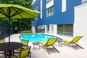 a patio with a table and chairs and a pool at SpringHill Suites Tallahassee Central in Tallahassee