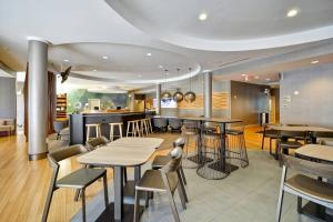 a restaurant with tables and chairs and a bar at SpringHill Suites Tallahassee Central in Tallahassee