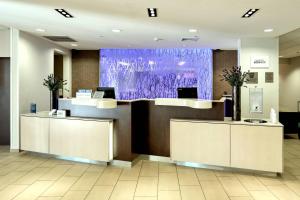 un vestíbulo con 2 escritorios y una pantalla púrpura en Fairfield Inn & Suites by Marriott Harrisburg West/New Cumberland, en New Cumberland