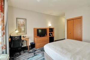 a hotel room with a bed and a desk and a television at Fairfield Inn & Suites by Marriott Harrisburg West/New Cumberland in New Cumberland