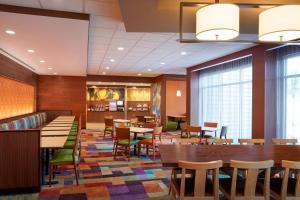 a dining room with tables and chairs and windows at Fairfield by Marriott Niagara Falls in Niagara Falls