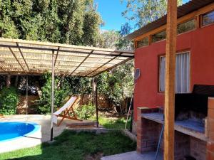 un patio con pérgola y piscina en Cabaña en Valle de Elqui en Horcon