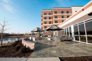 a patio with tables and umbrellas next to a building at TownePlace Suites by Marriott Chicago Schaumburg in Schaumburg