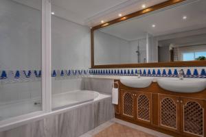 a bathroom with two sinks and a tub and a mirror at Marriott's Marbella Beach Resort in Marbella