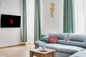 ein Wohnzimmer mit einem blauen Sofa und einem Couchtisch in der Unterkunft ARI Central Apartment 1 in Arad