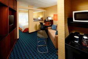 a hotel room with a bedroom with a bed and a desk at Fairfield Inn & Suites Parsippany in Parsippany