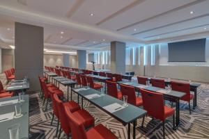 a conference room with tables and chairs and a projection screen at Fairfield by Marriott Bintulu Paragon in Bintulu