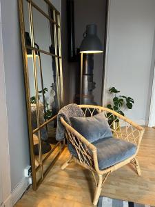 una sedia di vimini seduta davanti a uno specchio di Fredrikstad Cicignon, peaceful but central with garden, parking and long stay facilities a Fredrikstad