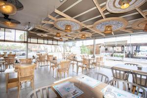 un restaurante con mesas, sillas y ventanas en Yianna Caravel "by Checkin", en Amoudara Herakliou