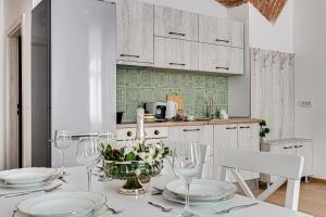 a kitchen with a table with glasses and flowers on it at ARI Central Apartment 1 in Arad
