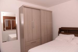 1 dormitorio con un gran armario de madera junto a una cama en Apto completo e aconchegante em Santa Rosa RS, en Santa Rosa