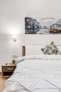 ein Schlafzimmer mit einem weißen Bett mit einem Bild an der Wand in der Unterkunft ARI Central Apartment 1 in Arad