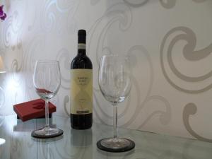 butelkę wina i dwa kieliszki wina na stole w obiekcie Elenoire Rooms & Suite w Rzymie +37 zdjęć