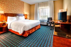 Fairfield Inn and Suites Oklahoma City Yukon في يوكون: غرفة فندقية بسرير وتلفزيون بشاشة مسطحة