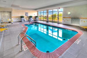 uma piscina num hotel com mesas e cadeiras em Fairfield Inn and Suites Oklahoma City Yukon em Yukon
