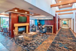 a lobby with a fireplace and chairs and a bar at Residence Inn Minneapolis Plymouth in Plymouth