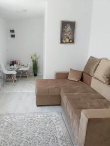 sala de estar con sofá marrón y mesa en Cazare Sarah, en Oţelu Roşu