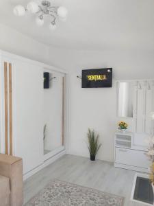 una sala de estar con un letrero de salida en la pared en Cazare Sarah, en Oţelu Roşu