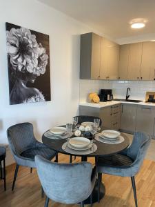 uma sala de jantar com uma mesa e cadeiras numa cozinha em Apartman Bella Fruške Residences em Vrdnik