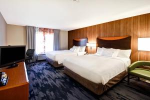 a hotel room with two beds and a flat screen tv at Fairfield Inn and Suites by Marriott North Platte in North Platte