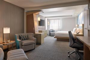 um quarto de hotel com uma cama e uma cadeira em Courtyard Denver Aurora em Aurora