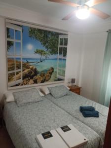1 dormitorio con ventana y 1 cama con libro en Apartamento Bajo en Valdelagrana, Primera Línea de Playa, en El Puerto de Santa María