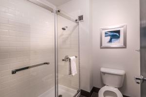 a bathroom with a toilet and a glass shower at Four Points by Sheraton Anchorage Downtown in Anchorage