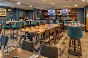 a restaurant with wooden tables and blue chairs at Four Points by Sheraton Anchorage Downtown in Anchorage