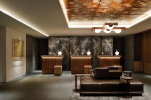 a lobby with a waiting room with a couch and chairs at The Chapter Kyoto, a Tribute Portfolio Hotel in Kyoto