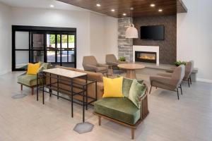 a lobby with chairs and tables and a fireplace at Fairfield Inn & Suites Columbia Downtown in Columbia