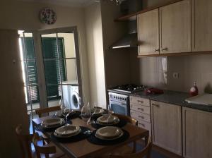 Una cocina con una mesa con platos y copas de vino. en Excelente T3 Duplex Funchal, en Funchal