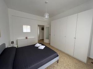 sypialnia z czarnym łóżkiem i białymi szafkami w obiekcie Manubella Appartamento 5 vani con giardino w mieście La Spezia