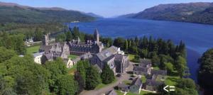an aerial view of a castle in the middle of a lake at The Cabin, Stronua. A beautiful 1 bedroom cabin. in Fort Augustus