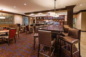 a restaurant with a bar and tables and chairs at Courtyard by Marriott Odessa in Odessa