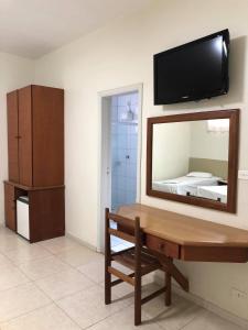 a room with a mirror and a dresser and a bed at Regio Plaza Hotel in Ourinhos