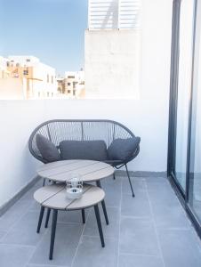 Un banco y una mesa en un balcón. en Sarah's Penthouse in Sliema, en Sliema